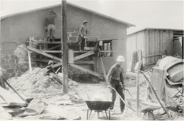 Na pierwszym planie murowany budynek gospodarczy, a w głębi szopa drewniana na sprzęt i materiały budowlane (1984 r.)